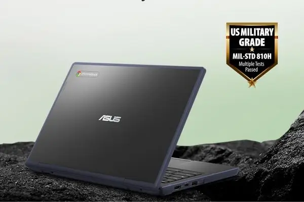 A dark blue/grey ASUS Chromebook sitting partially open on a rough,